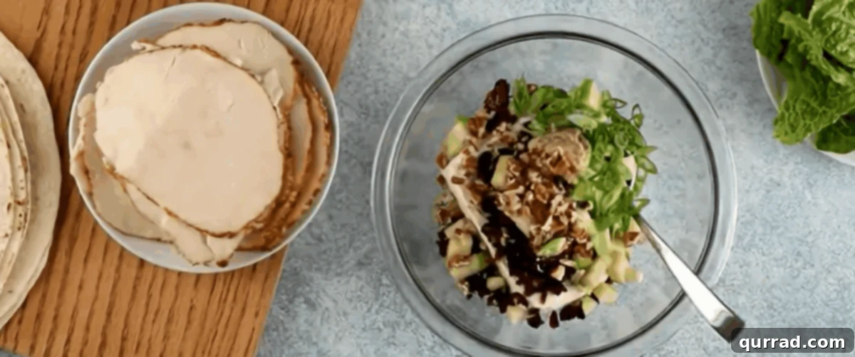 Spiral Chicken Salad Bites 5 Combining cream cheese with the add-ins for chicken salad pinwheels in a bowl, showing a creamy texture.