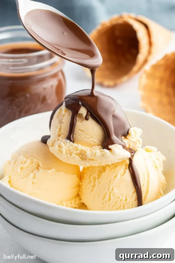 Chocolate Crackle Topping 4 A spoon generously pouring rich Chocolate Magic Shell over a creamy scoop of vanilla ice cream, promising an instant hardening effect.