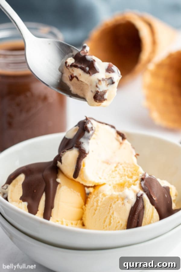 Chocolate Crackle Topping 5 Cracked Chocolate Magic Shell on a scoop of vanilla ice cream held on a spoon, illustrating the perfect crunchy texture.