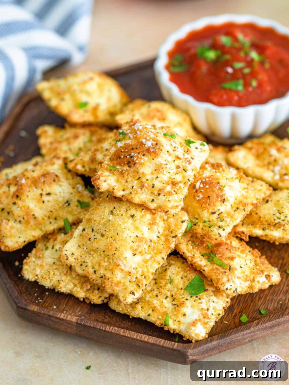 Crispy Air Fryer Ravioli Bites 4 A generous pile of perfectly air-fried toasted ravioli resting on a rustic wooden serving tray, ready to be enjoyed.