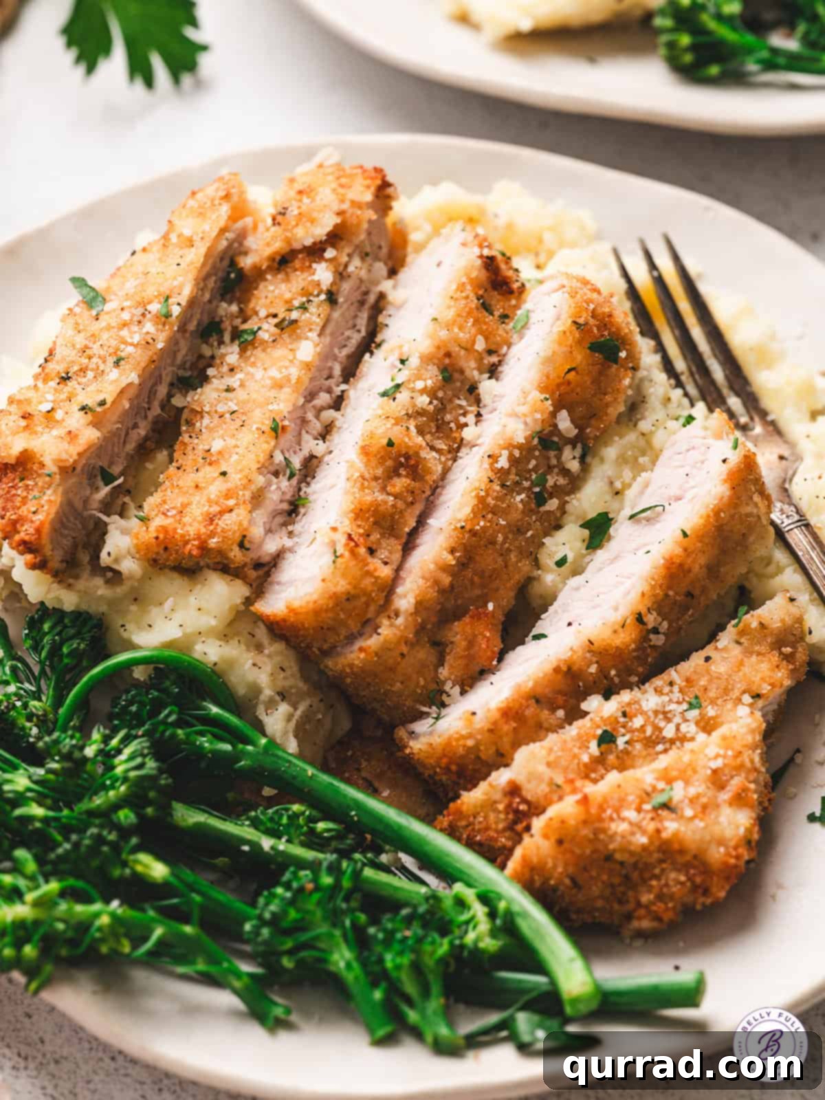 Crispy Air Fryer Pork Chops 11 Plated air fryer pork chops, sliced to show the juicy interior, served with creamy mashed potatoes