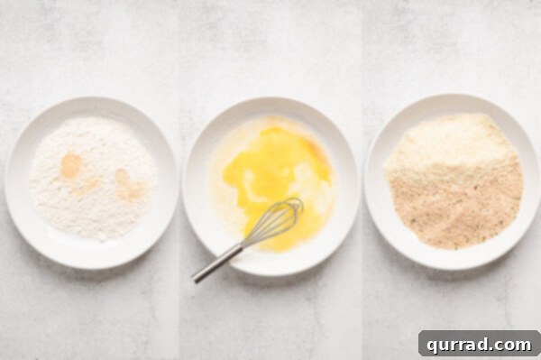Three shallow bowls containing flour mixture, whisked eggs, and breadcrumb mixture for breading