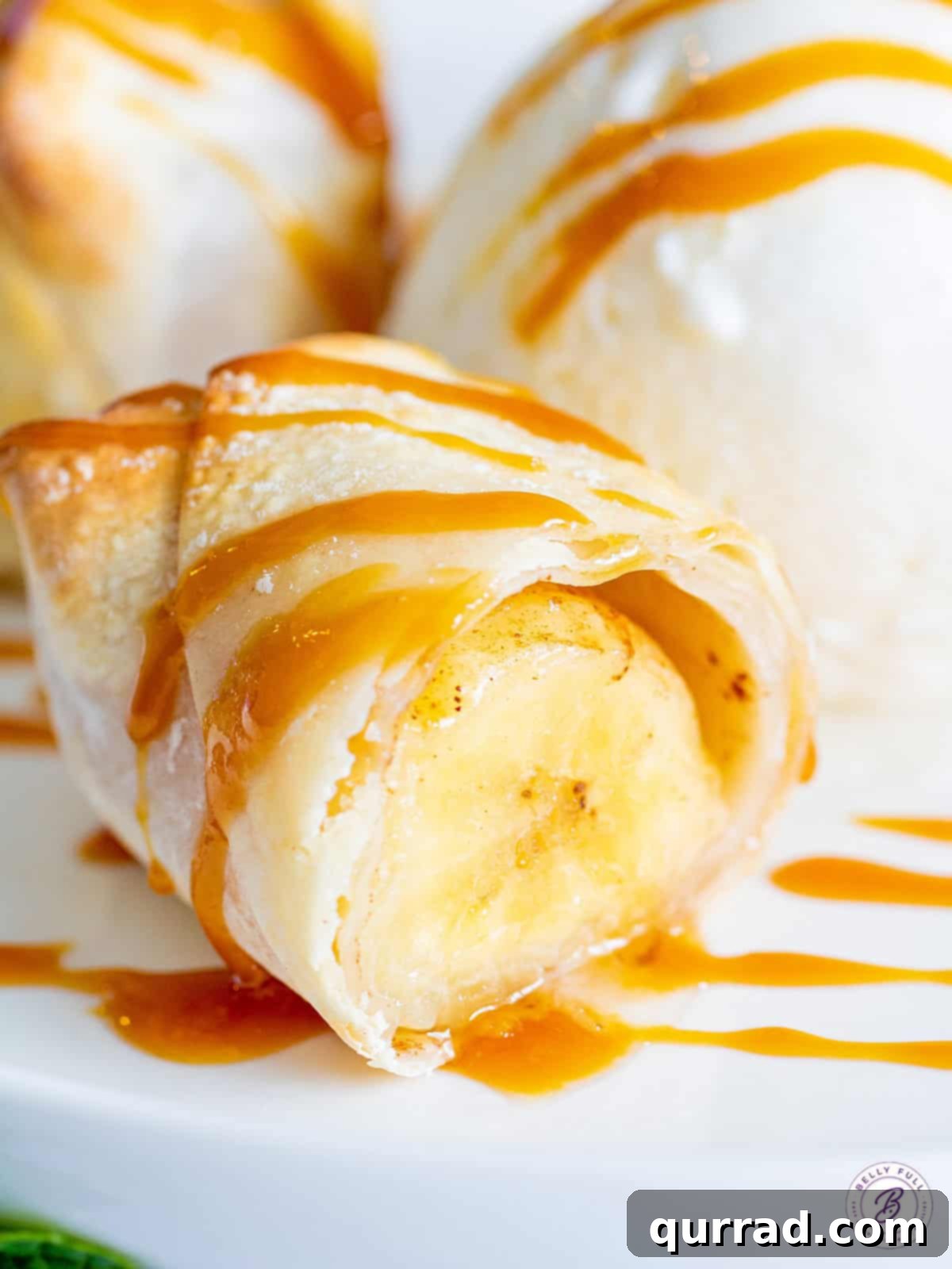 Crispy Air-Fried Banana Rolls 2 Crispy banana lumpia cut in half, revealing the warm banana filling, elegantly drizzled with rich caramel sauce.