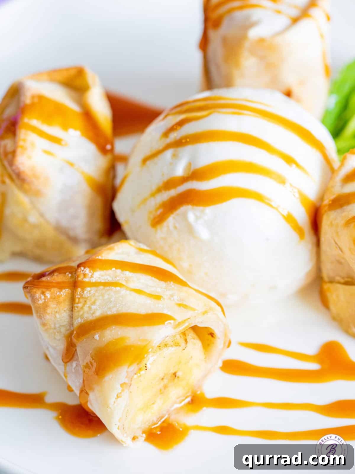 Crispy Air-Fried Banana Rolls 5 Delicious air fryer banana lumpia served on a plate, cut open to show the soft banana interior, elegantly drizzled with caramel sauce.