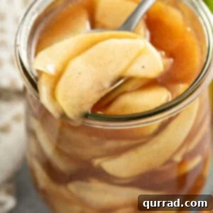 Effortless Homemade Apple Pie Filling 6 portion of apple pie filling on spoon over glass jar