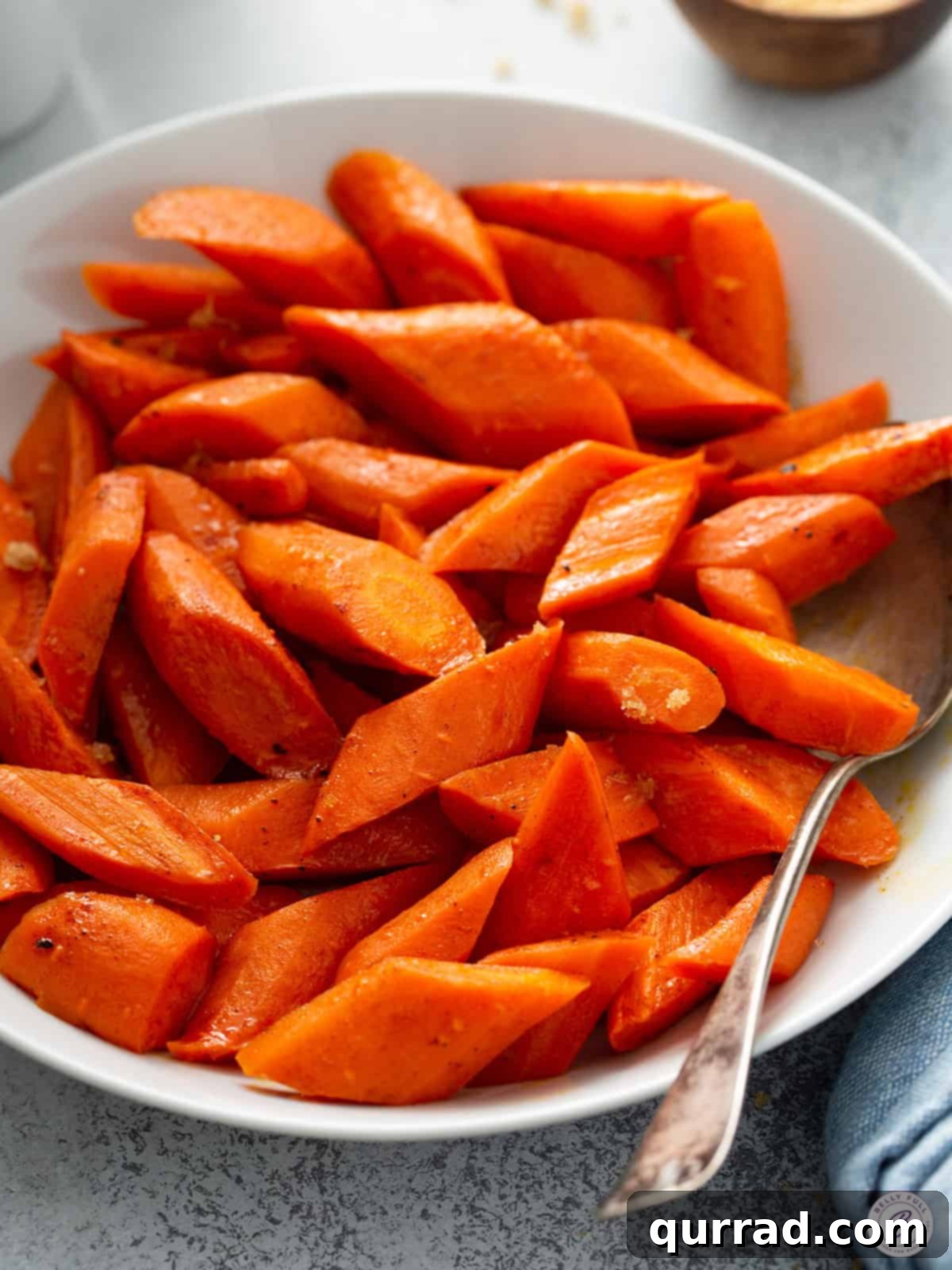 Golden Roasted Carrots 2 Serving bowl filled with perfectly golden oven roasted carrots, garnished with fresh herbs, ready to be served as a healthy side dish.