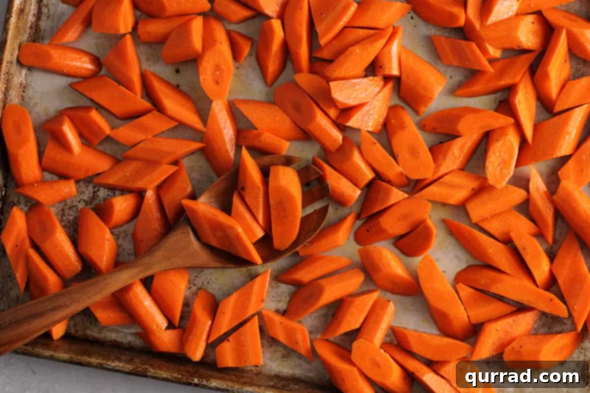 Golden Roasted Carrots 5 Sliced carrots arranged on a large rimmed baking sheet, drizzled with olive oil and seasoned with salt and pepper.