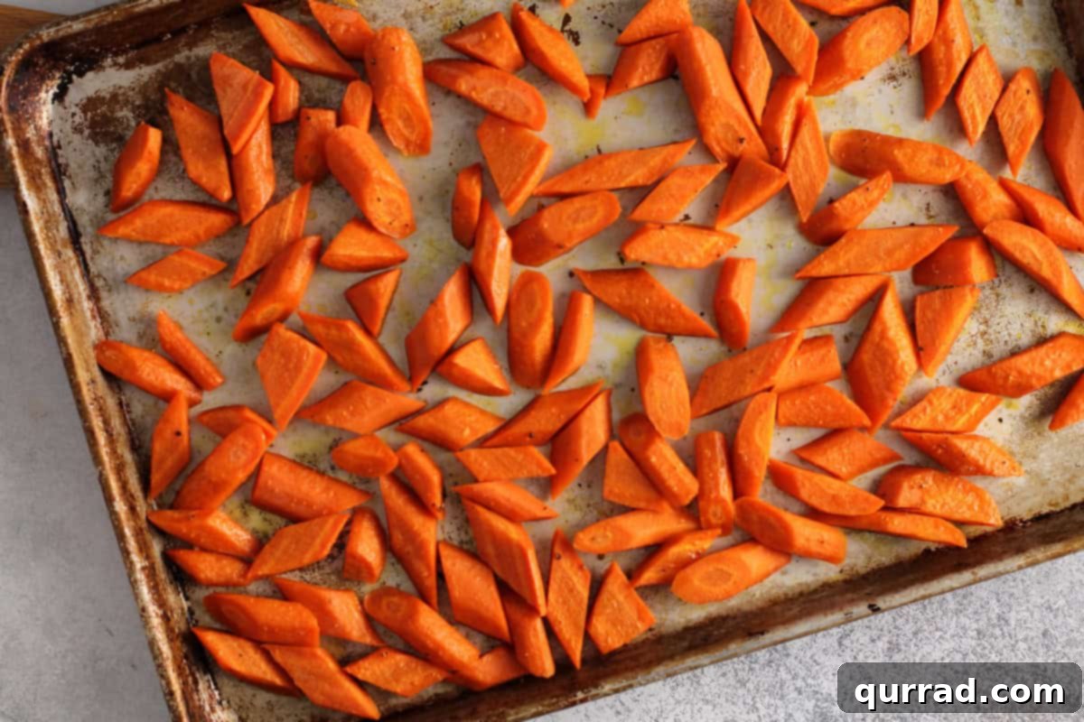 Golden Roasted Carrots 6 Oven roasted carrots on a baking sheet, golden brown and tender, straight from the oven.