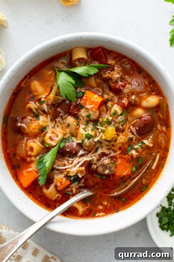Homemade Olive Garden Pasta Fagioli Soup 2 Overhead shot of a bowl of Pasta Fagioli soup with a spoon, highlighting its rich texture and ingredients.