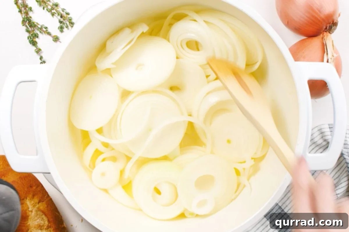 sliced onions being stirred in pot with butter