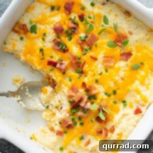 overhead mashed cauliflower bake in white dish with serving spoon
