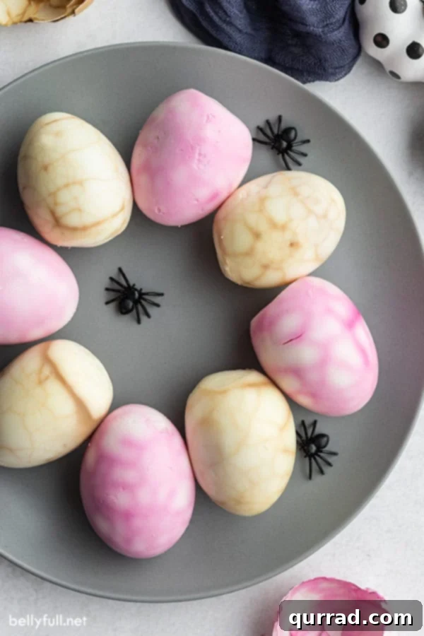 Eerie Webbed Eggs 4 overhead of spiderweb hard boiled eggs on gray plate with Halloween decorations