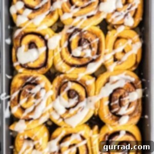 overhead of pan with pumpkin cinnamon rolls with icing