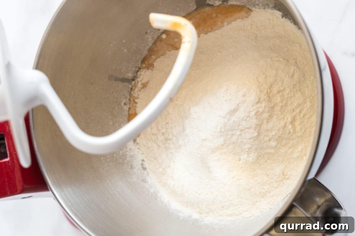Autumn Spice Pumpkin Rolls 5 Making the dough for pumpkin cinnamon rolls in the bowl of a stand mixer with a dough hook.