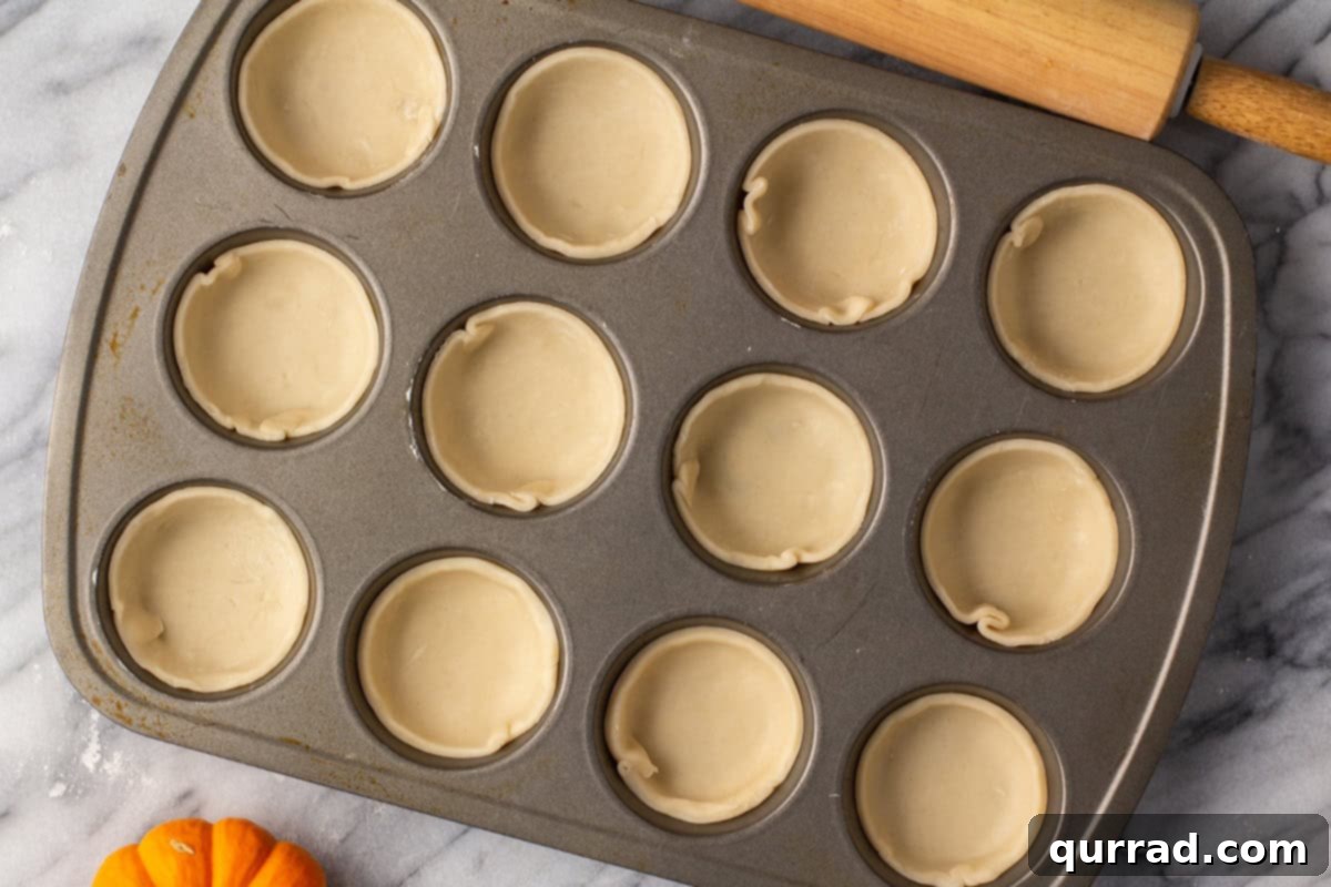 Bite-sized Pumpkin Delights 6 Mini pie crusts neatly placed and pressed into a muffin tin.