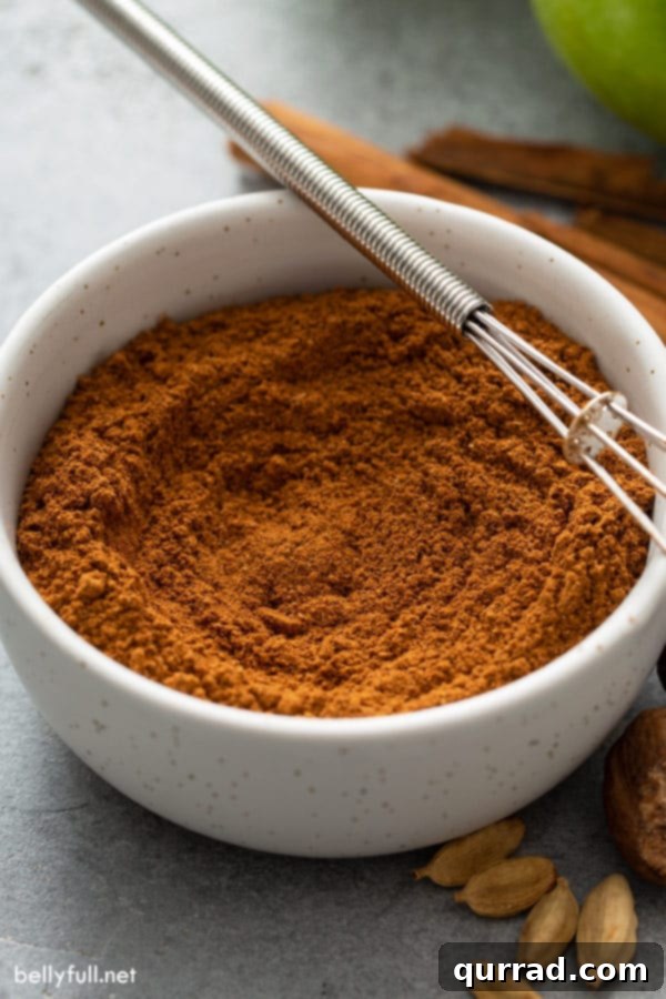 Signature Apple Pie Spice Blend 4 blended apple pie spice in bowl with tiny whisk