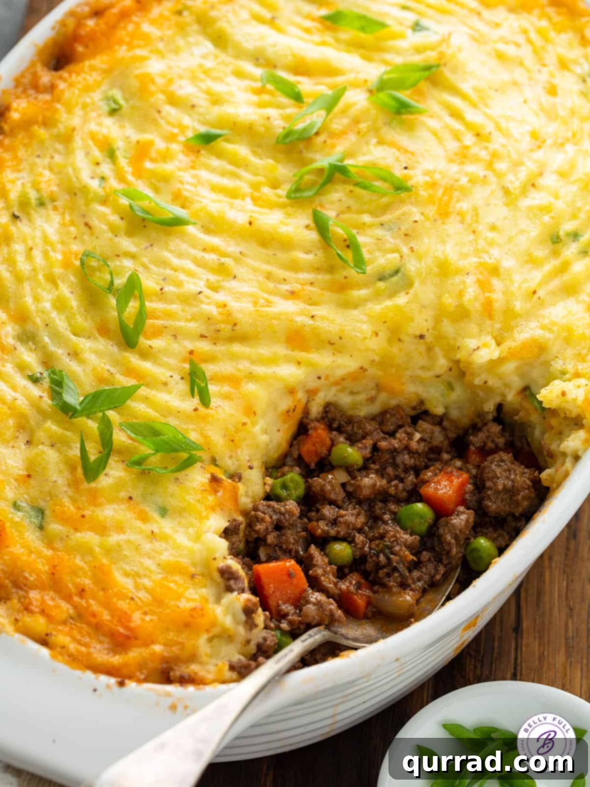 Rustic Lamb and Potato Bake 3 ground beef filling and mashed potatoes on serving spoon