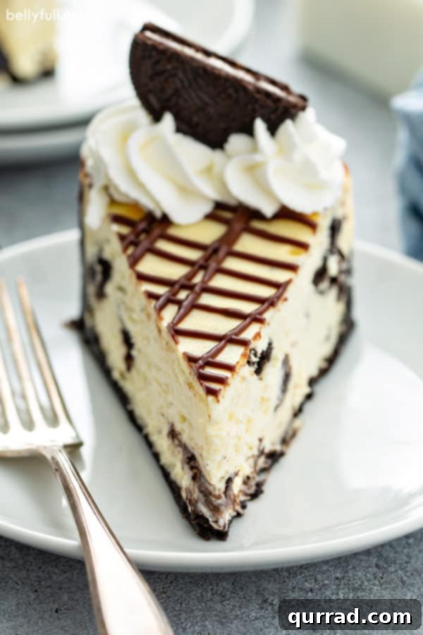 Decadent Oreo Cheesecake 2 Close up picture of a perfectly sliced Oreo cheesecake on a white plate, showcasing its creamy texture and cookie pieces