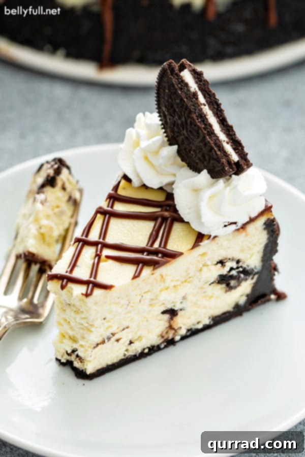 Decadent Oreo Cheesecake 11 A slice of Oreo cheesecake with a bite taken, beautifully garnished with an Oreo cookie and whipped cream, ready to be enjoyed.