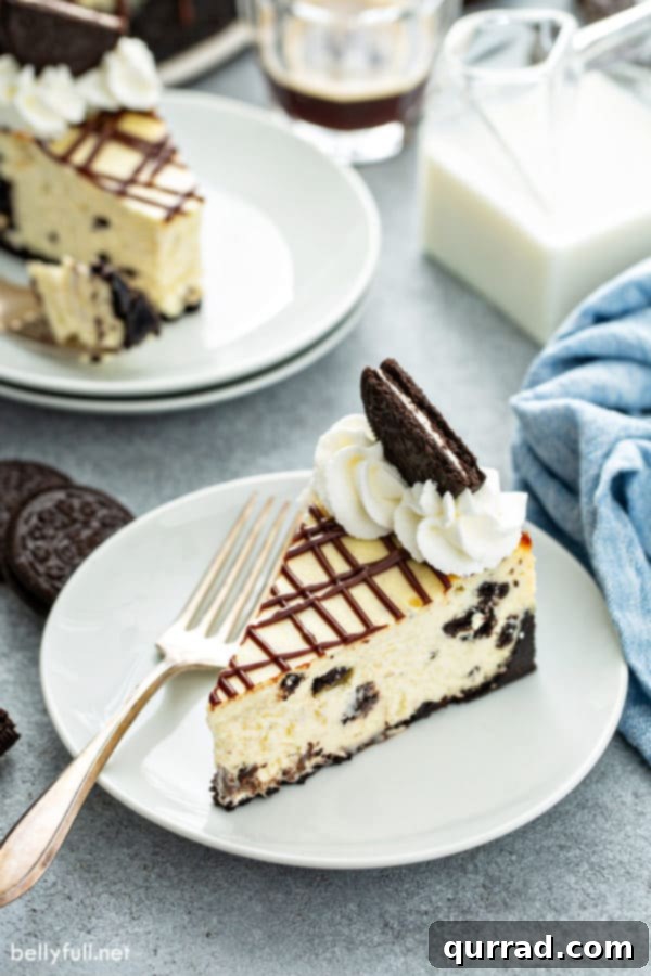 Decadent Oreo Cheesecake 12 A perfectly portioned slice of Oreo cheesecake on a white plate with a fork, ready to be enjoyed.