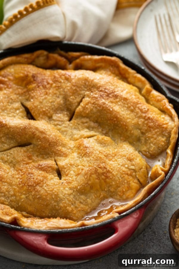 Side angle shot of a slice of easy apple pie, showing the gooey caramel, tender apples, and crisp crust