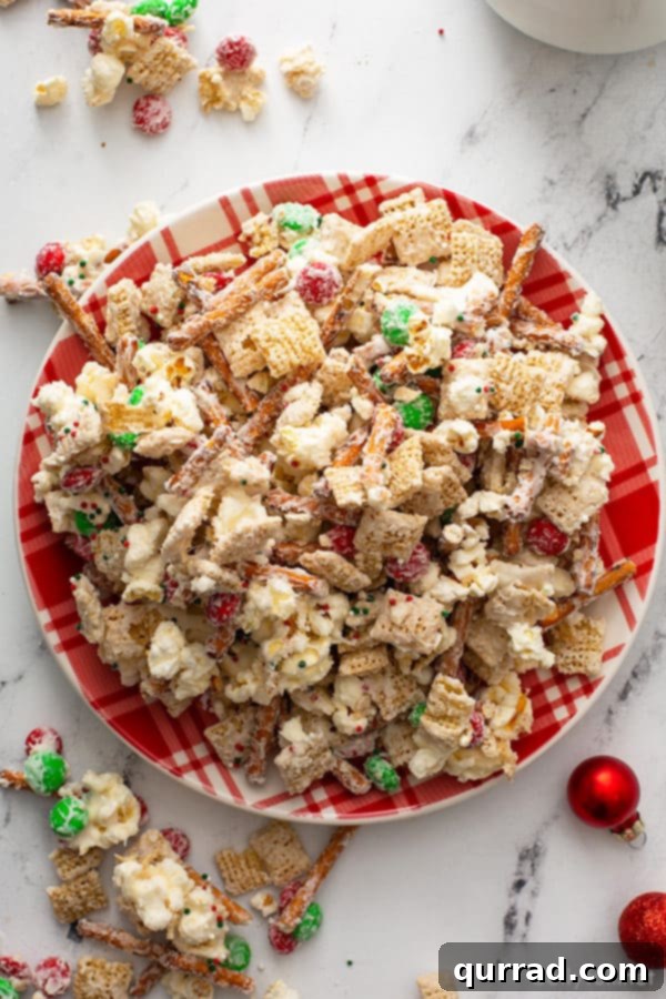 Christmas Reindeer Crunch 2 Delicious overhead view of Reindeer Chow Christmas snack mix elegantly displayed on a festive holiday plate, showcasing its vibrant colors and textures.