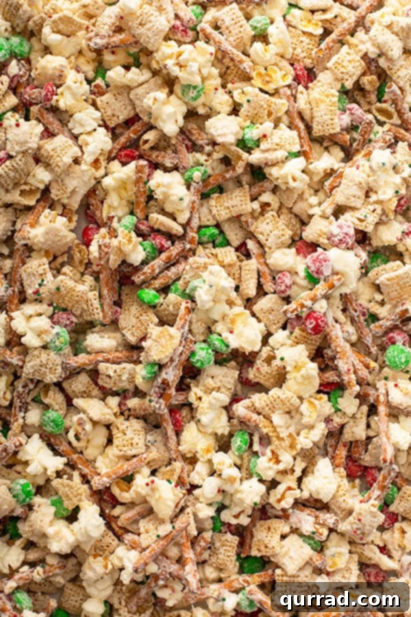 Christmas Reindeer Crunch 3 Close-up view of the irresistible Reindeer Chow snack mix spread out on a baking sheet, highlighting the delicious chocolate coating and colorful M&M's.