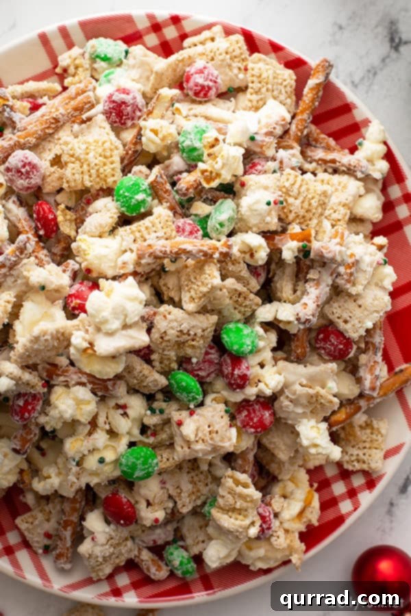 Christmas Reindeer Crunch 5 Close-up overhead shot of the vibrant Christmas Reindeer Chow, perfectly arranged on a festive red and white striped plate, ready to be enjoyed.