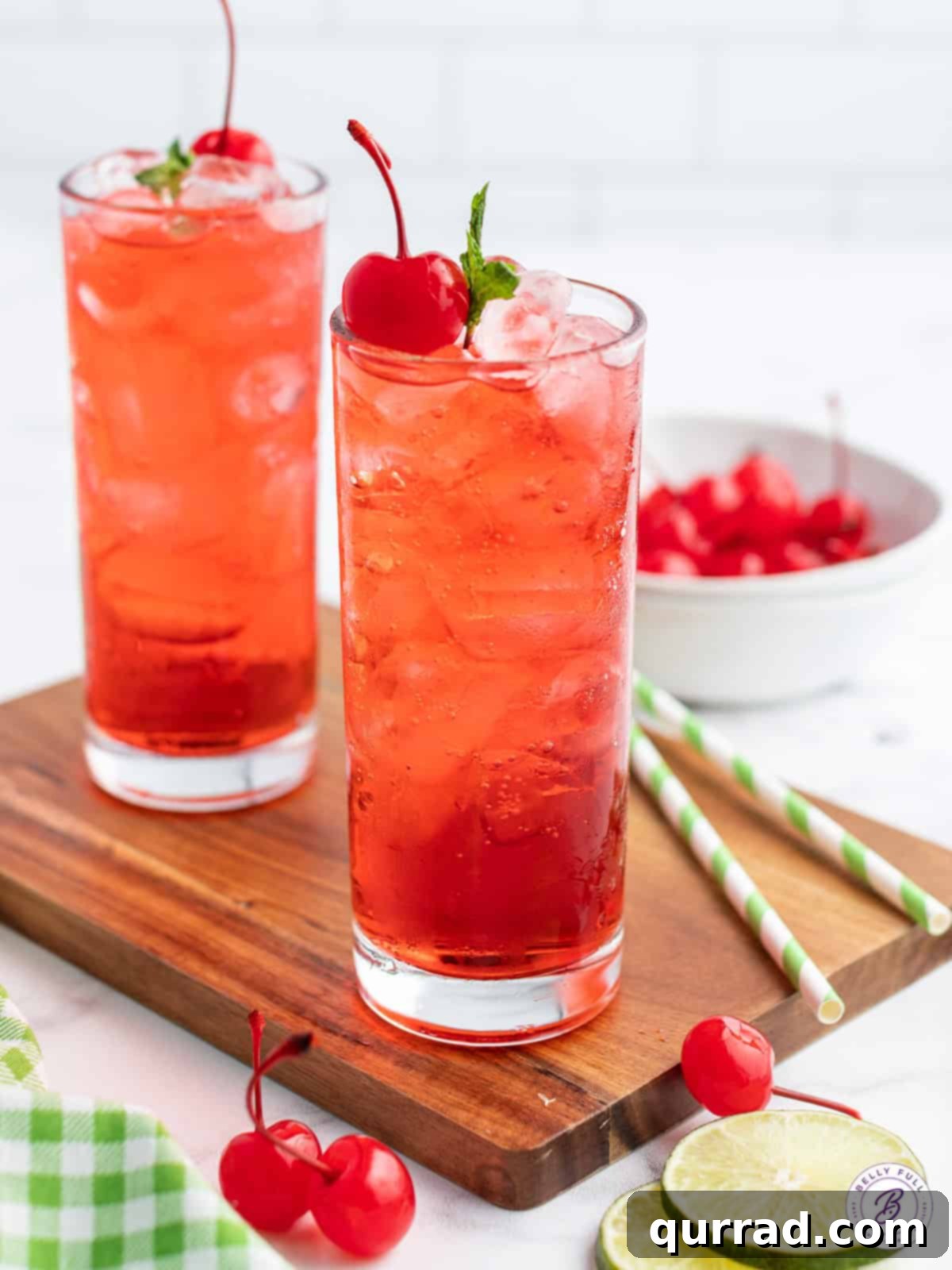 Fizzy Shirley Temple drink in a highball glass, garnished with a bright red maraschino cherry and a sprig of fresh mint, reflecting a warm, inviting glow.