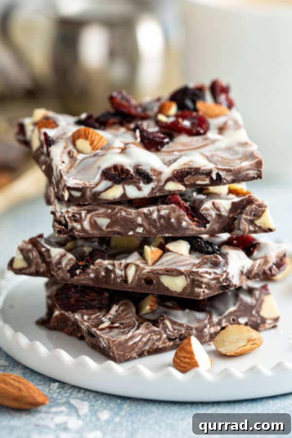 Sweet-Tart Cranberry Almond Chocolate Bark 3 A four-piece stack of cranberry almond chocolate bark, highlighting the beautiful marble effect and rich ingredients.