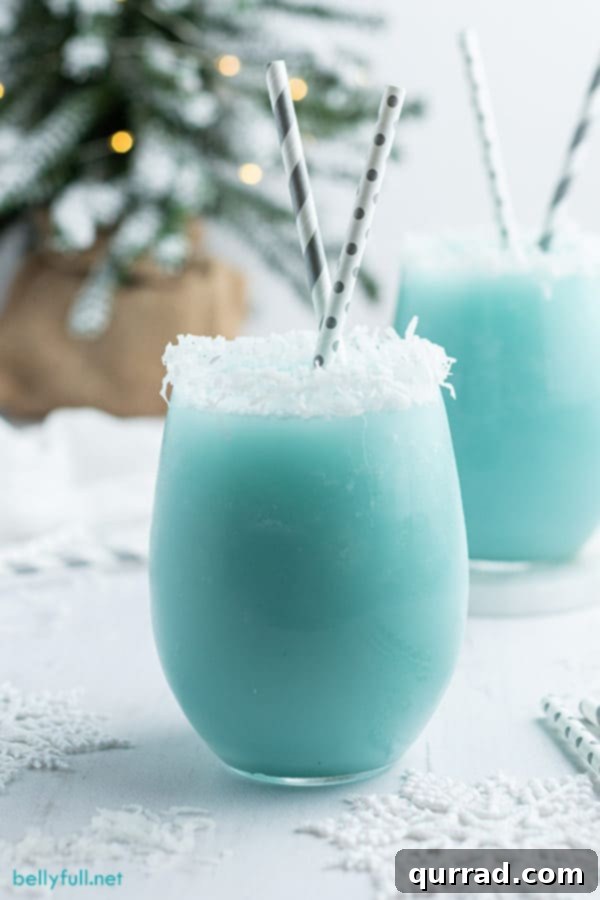 Blue snowy Winter Cocktail in a glass with a straw, ready to drink