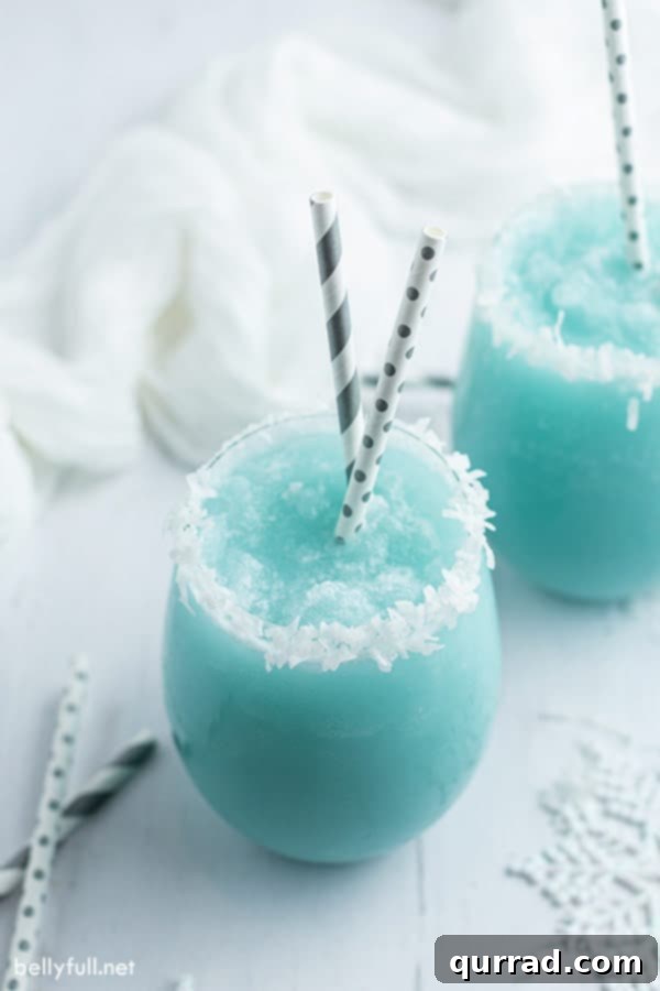 Jack Frost Winter Cocktail in a glass with coconut flakes and straws, festive and ready for holiday parties