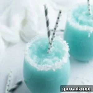 Jack Frost Winter Cocktail in glass with coconut flakes and straws