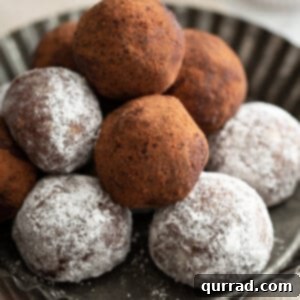 stack of rum balls coated in powdered sugar and cocoa powder