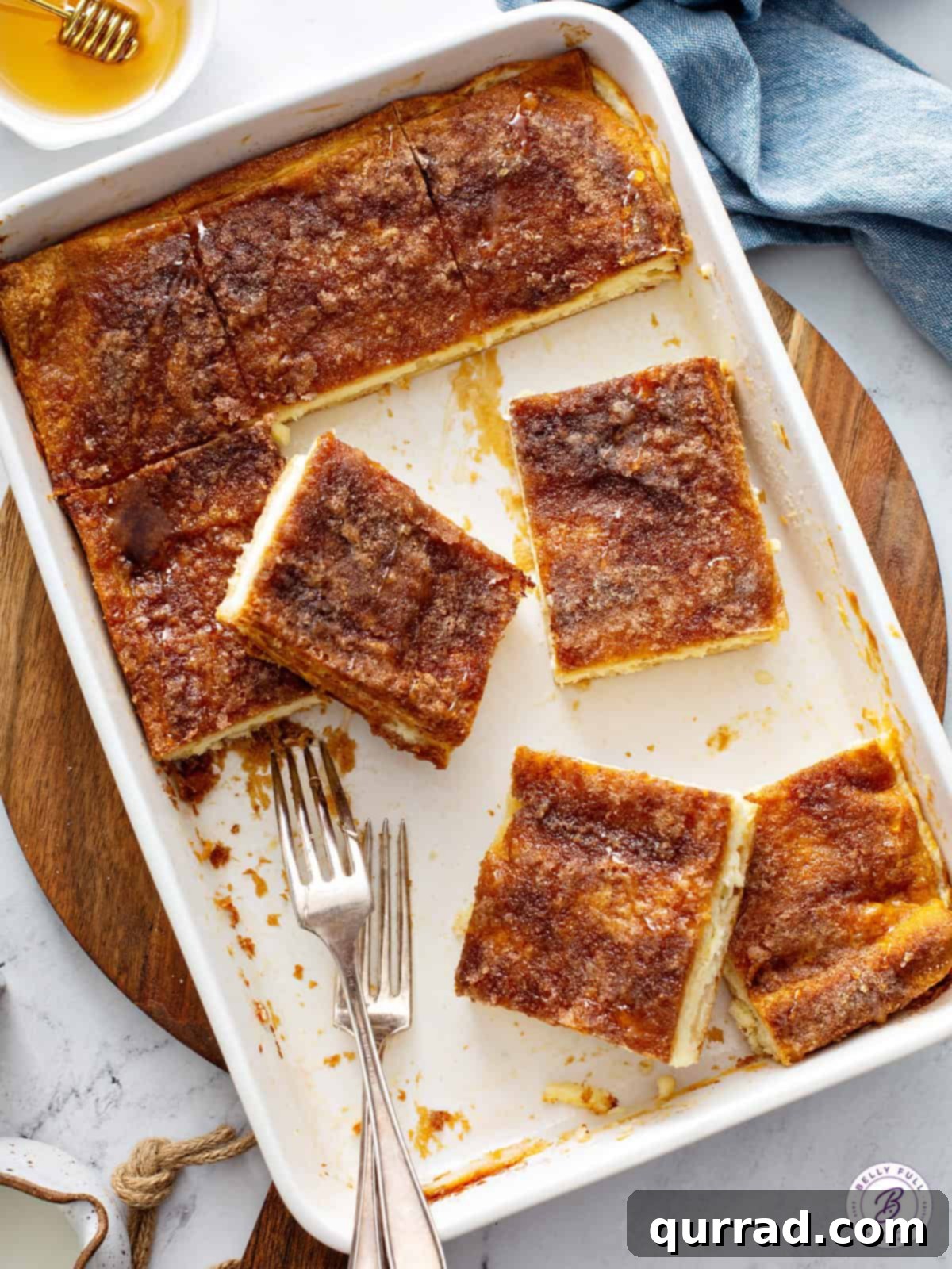 Honey Kissed Sopapilla Cheesecake 3 Overhead view of a pan of perfectly sliced Sopapilla Cheesecake bars, ready to serve