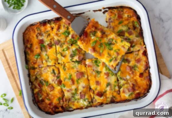 A freshly baked and sliced hash brown egg casserole, served on a spatula, revealing its delectable layers.