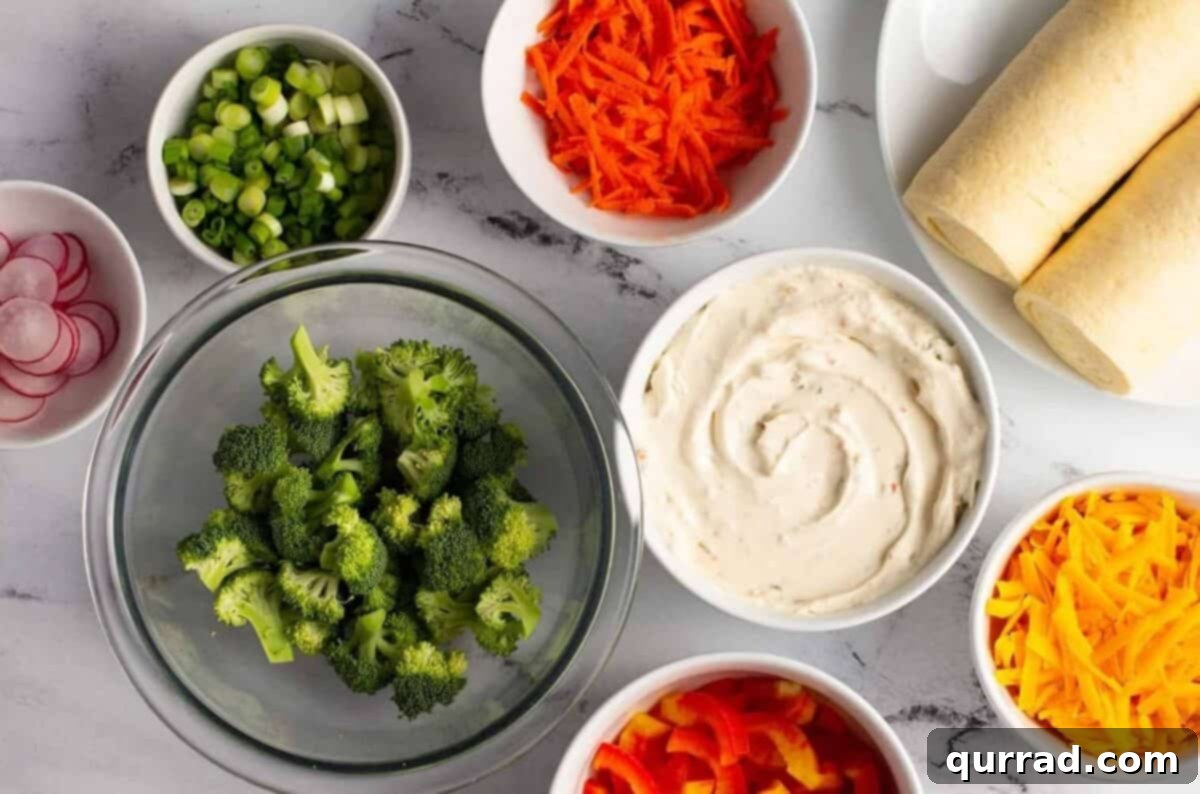 A vibrant collection of fresh ingredients laid out on a countertop, including two cans of crescent roll dough, tubs of garden veggie cream cheese, a bowl of shredded cheddar, and various finely chopped raw vegetables like broccoli, bell peppers, carrots, and scallions, all ready for the Cold Veggie Pizza assembly.