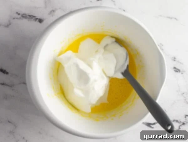whipped egg whites being folded into beaten egg mixture