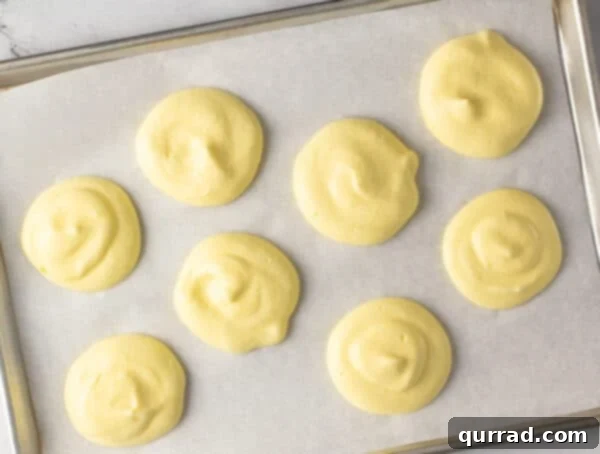 unbaked mounds of cloud bread on parchment paper
