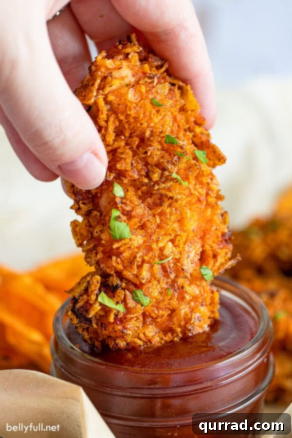 Air Fryer BBQ Chicken Tenders 2 air fryer chicken tenders being dipped into BBQ sauce