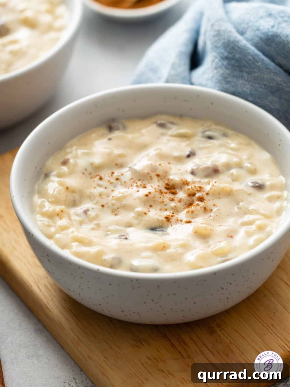 Bowl of Bliss 2 A bowl of rich, creamy Rice Pudding with raisins and a sprinkling of cinnamon, ready to be enjoyed.