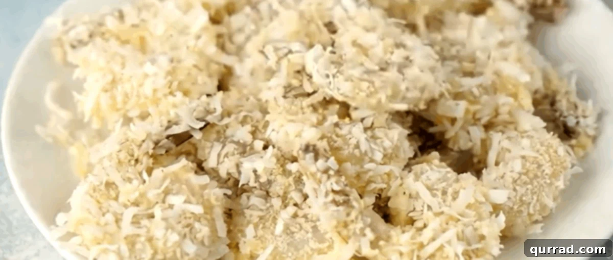 Crispy Air Fryer Coconut Shrimp 6 Raw shrimp fully coated in the coconut-panko breading, arranged neatly on a plate, ready for air frying.