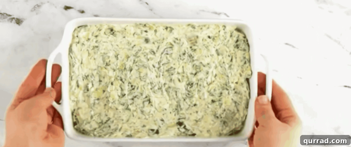 Spinach artichoke dip in a baking pan.