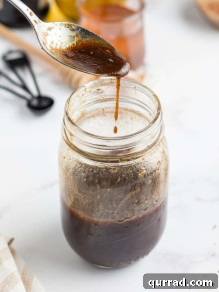 Velvet Balsamic Elixir 3 Balsamic Vinegar Dressing dripping off of spoon into jar
