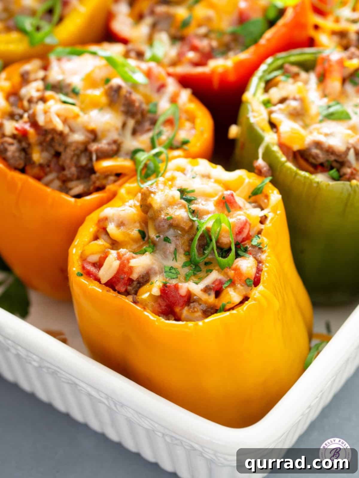 Flavor-Packed Peppers 11 Fırında eritilmiş peynirli dolgulu biberlerin bir güveç kabında üstten görünümü, lezzetli iç harcı ve altın rengi erimiş peyniri vurgulanıyor.