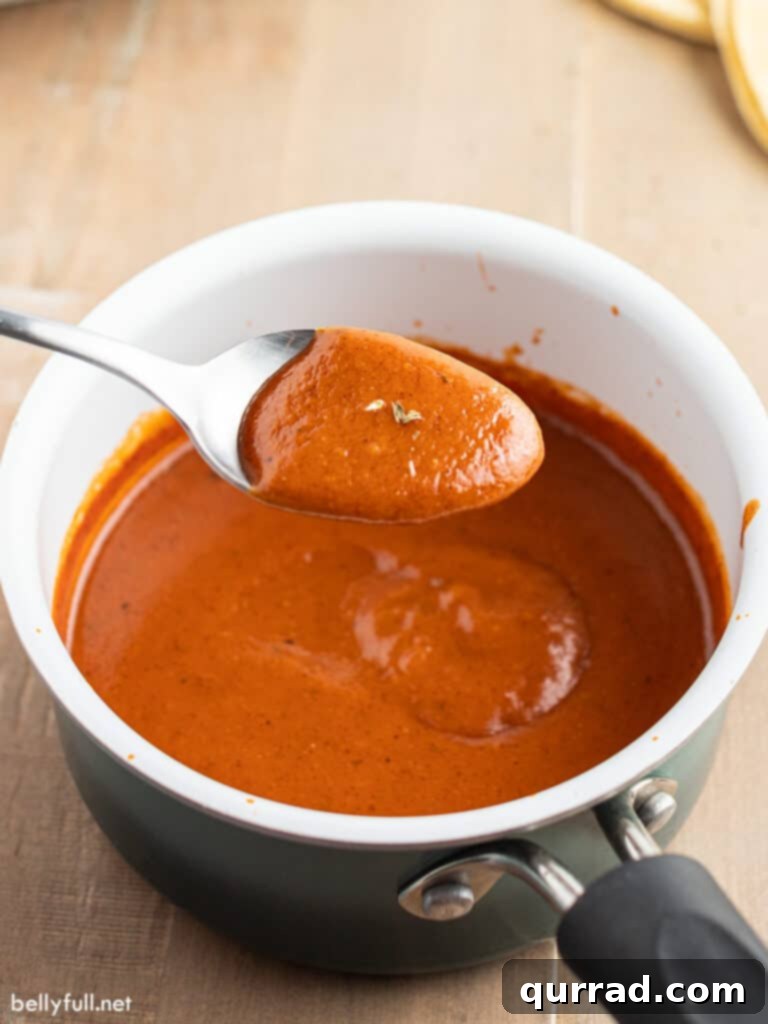 Authentic Homemade Enchilada Sauce 4 Homemade enchilada sauce on a spoon over a saucepan