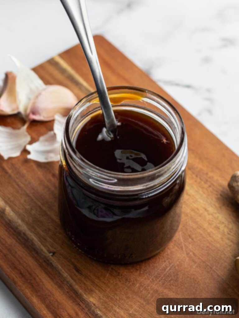 Teriyaki Perfection: Made From Scratch 2 Homemade Teriyaki sauce in a glass jar with a spoon, ready to be used in various dishes.