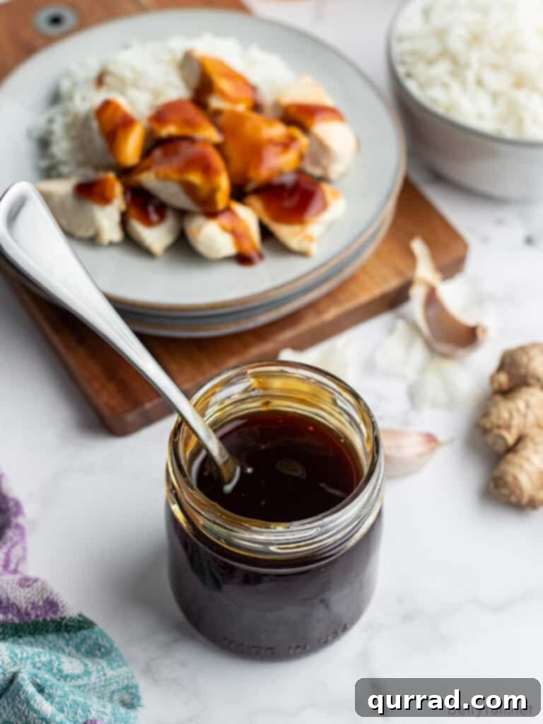 Teriyaki Perfection: Made From Scratch 3 Glass jar of homemade Teriyaki sauce with blurred chicken in the background, suggesting its culinary use.