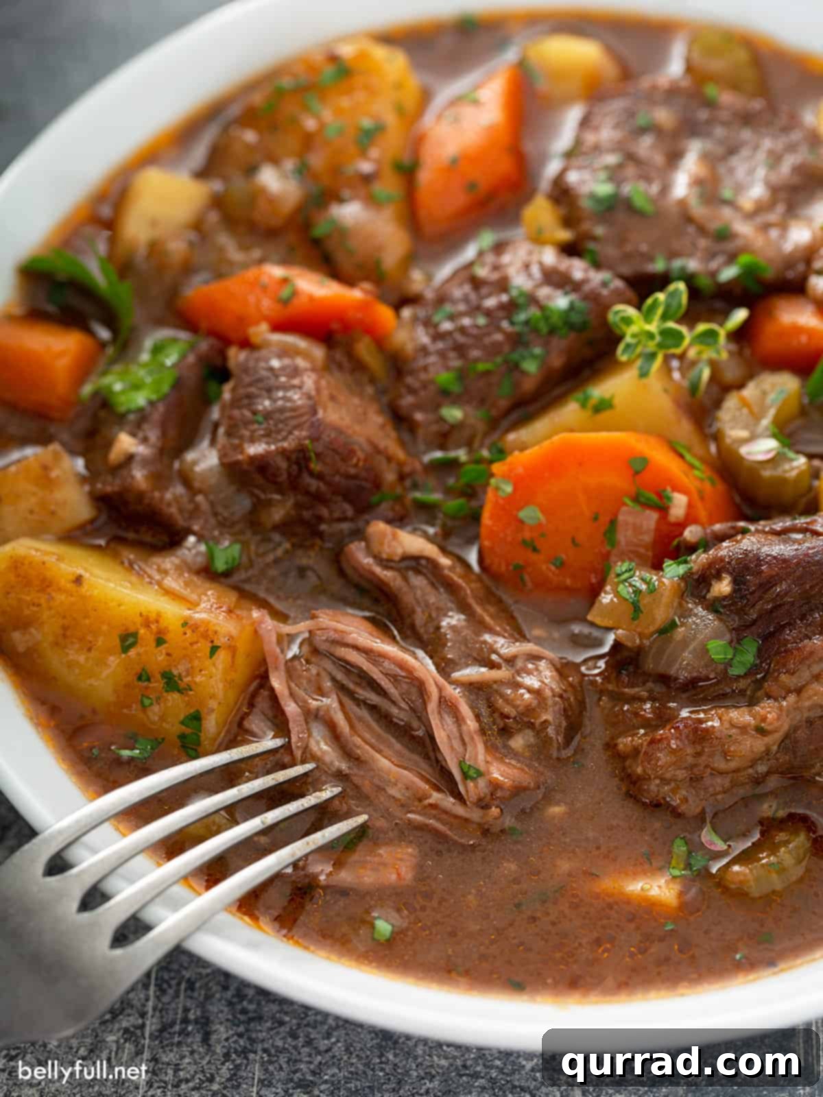 Hearty Irish Beef Stew 4 Close-up of a piece of shredded beef from Guinness beef stew in a bowl, showing its tenderness.