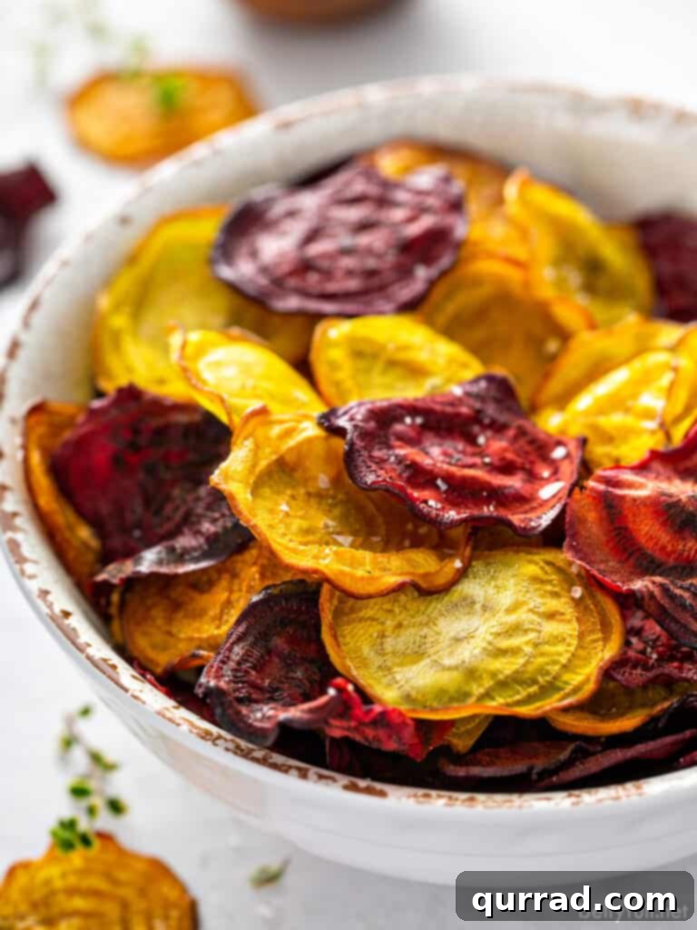 Crispy Beetroot Snaps 5 A bowl filled with a mix of red and golden baked beet chips, showcasing their irresistible crunch and vibrant colors, ready to be enjoyed.